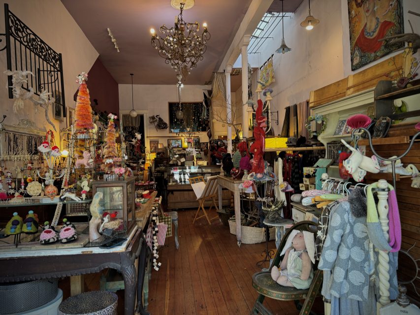 A store with a lot of handmade shoes, clothes and artifacts in it.