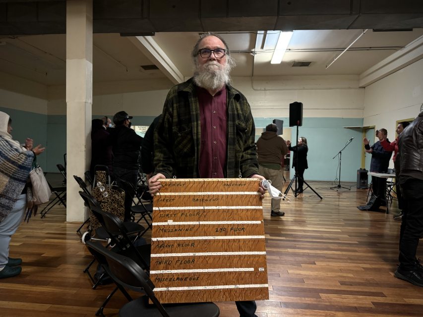 A man holding a sign in a room.