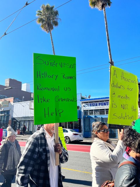 A group of vendors holding signs, marching down Mission Street and protesting the Mission street-vending ban.