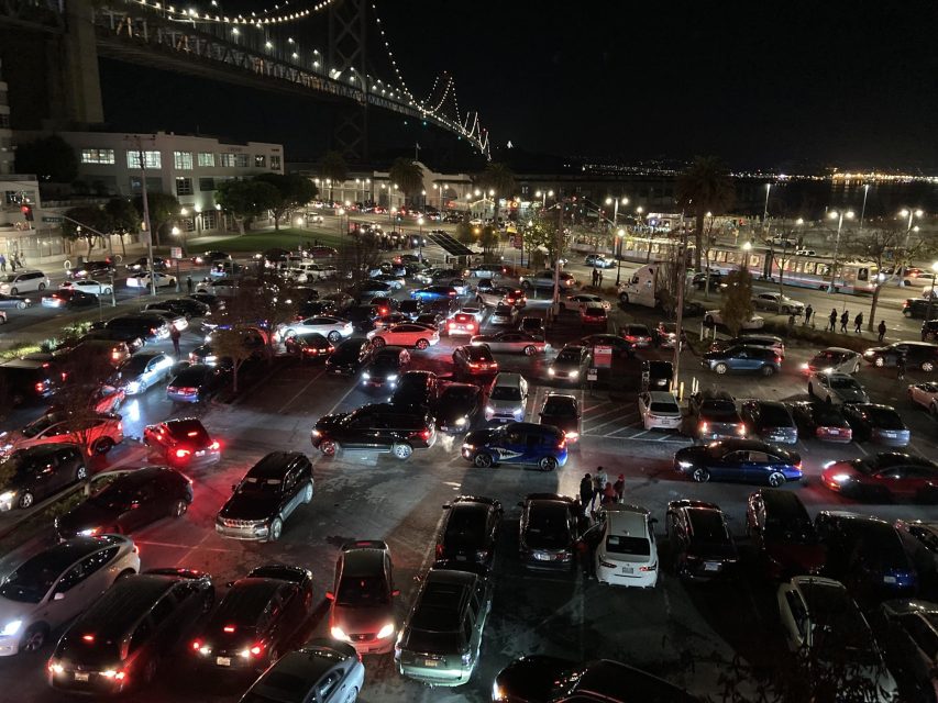 A lot of cars parked in a parking lot at night.