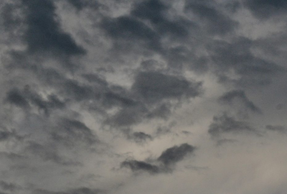 A plane flying over a cloudy sky.