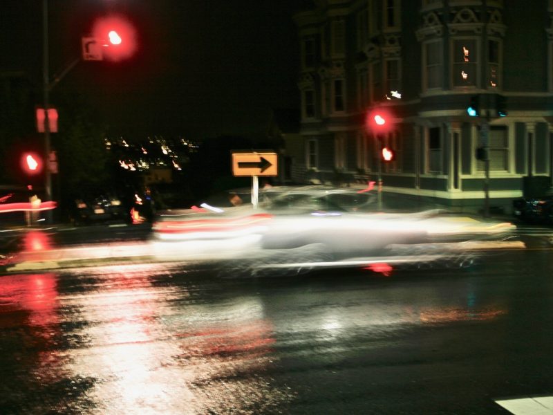 A car driving down a street at night.