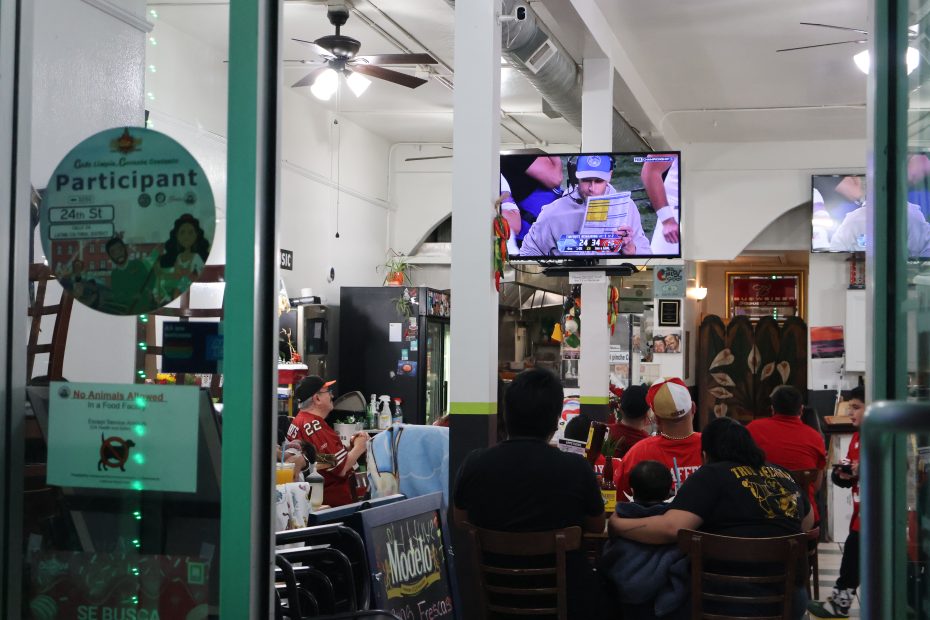 A group of people sitting in a restaurant watching the 49ers