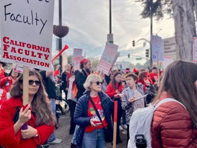 A group of people in red holding signs that say CFA and SF State.