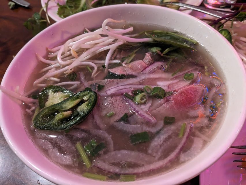 A bowl of soup with meat and vegetables in it.