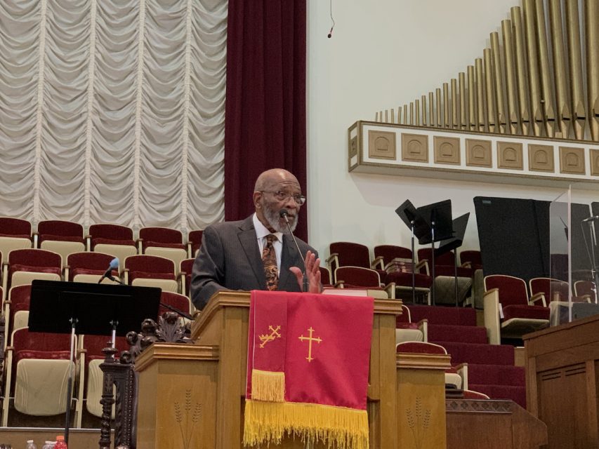 A man in a suit standing at a podium.