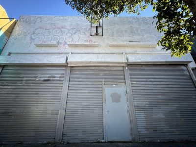 An empty storefront with signs fading