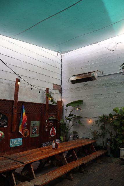 A wooden bench next to a pool.