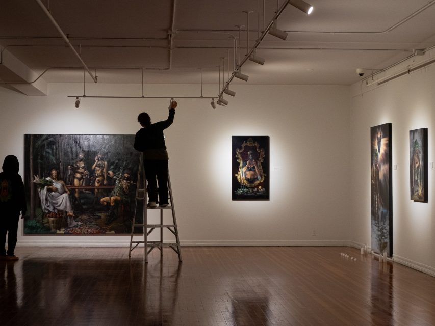 A group of people fixing the lighting in an art gallery.