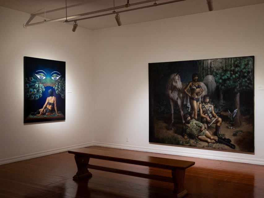 Paintings in an art gallery with a bench.