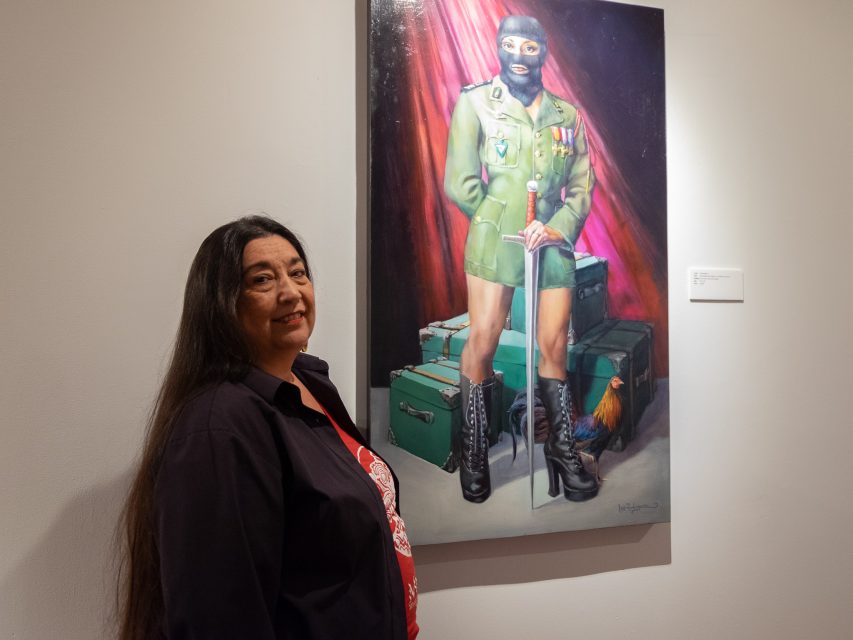 A woman standing next to a painting