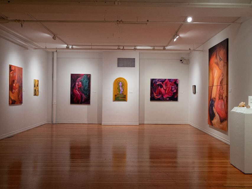 An art gallery with paintings on the walls.