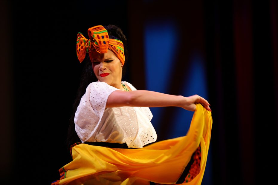 Woman performing a traditional dance with a colorful scarf. She is competing to rule Carnaval.