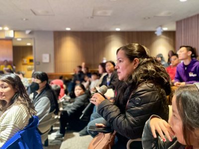 A group of people sitting in a room with microphones.
