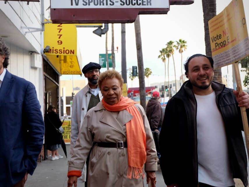 Barbara Lee walking down Mission Street next to Kevin Ortiz, president of the San Francisco Latinx Democratic Club