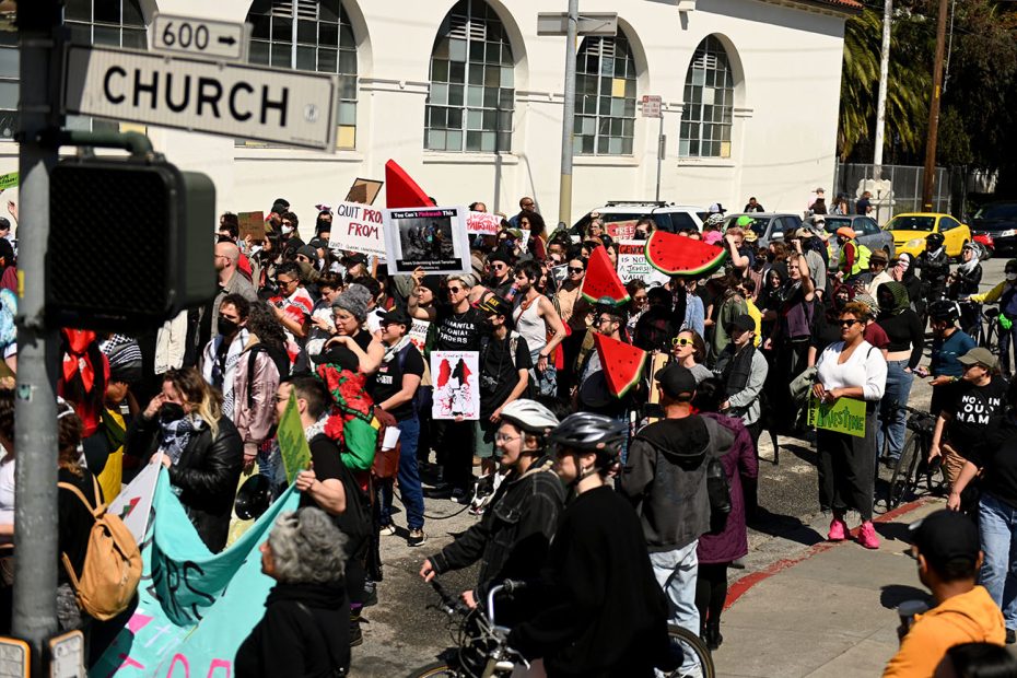 Protesters marching with signs on a city street.