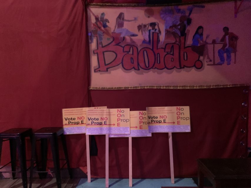 A series of No on E signs leaning up against a wall