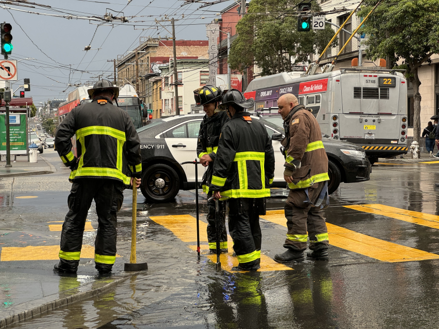Firefighters working to shut down a water main after a fire hydrant was struck ,gushing water into the air at 16th and Mission streets