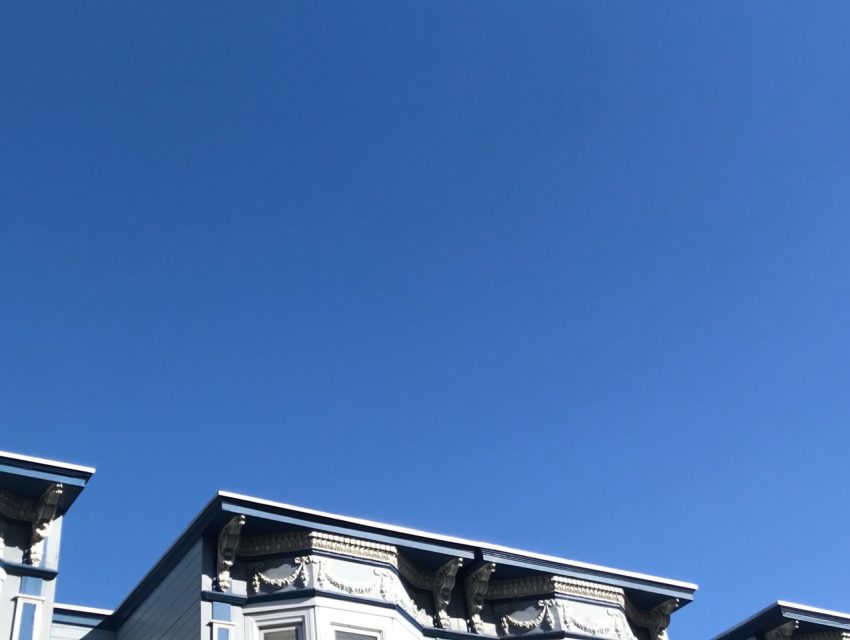 Victorian-style house facade against a clear blue sky.