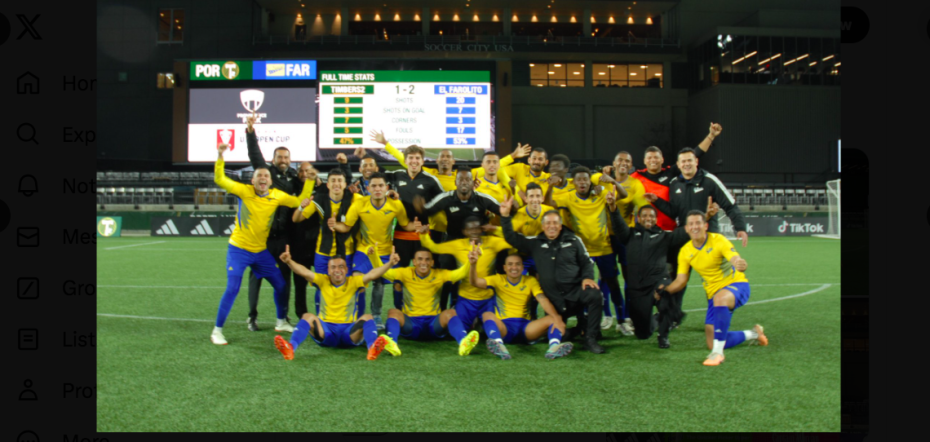 Celebratory group photo of a soccer team on the field after a victory.