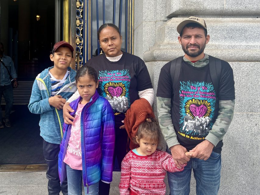 A newcomer family of five standing in front of San Francisco City Hall.