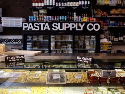 A well-stocked pasta section in Pasta Supply Co. with an assortment of fresh pasta options on display.