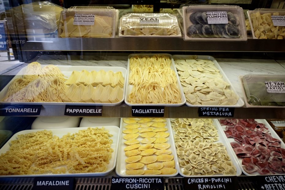 Various types of fresh pasta on display in a deli case.