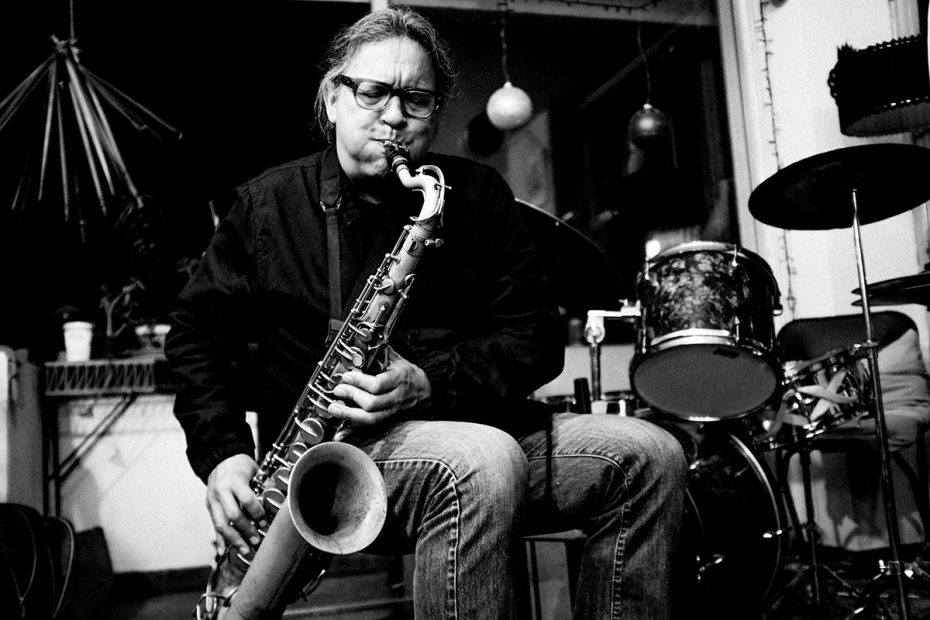 Musician playing a saxophone on stage.