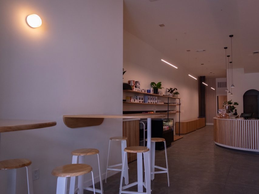 Modern minimalist cafe interior with bar stools and counter.