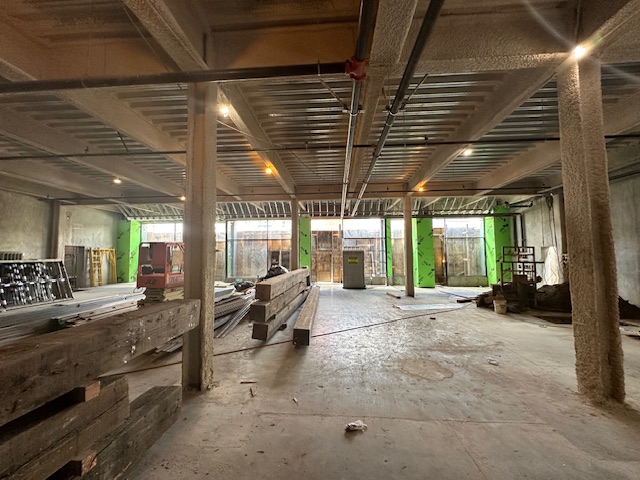 Interior of the building under construction with exposed pillars and beams.