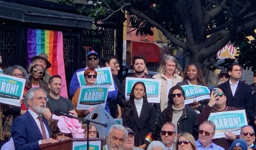 A group of people attending a public event with signs supporting Aaron Peskin.