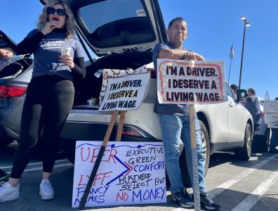 Protesters holding signs advocating for fair wages for drivers, part of Gig Workers Rising.